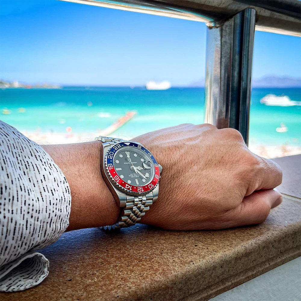 Hand wearing a watch with a scenic ocean view in the background